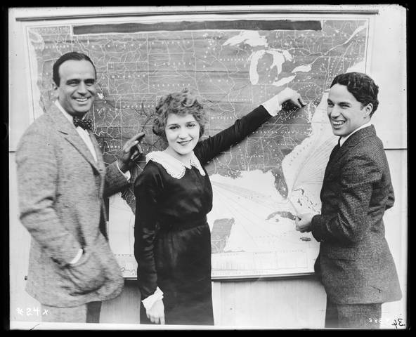 Douglas Fairbanks, Mary Pickford and Charlie Chaplin posing in front of a map, 1918 Liberty Loan Drive